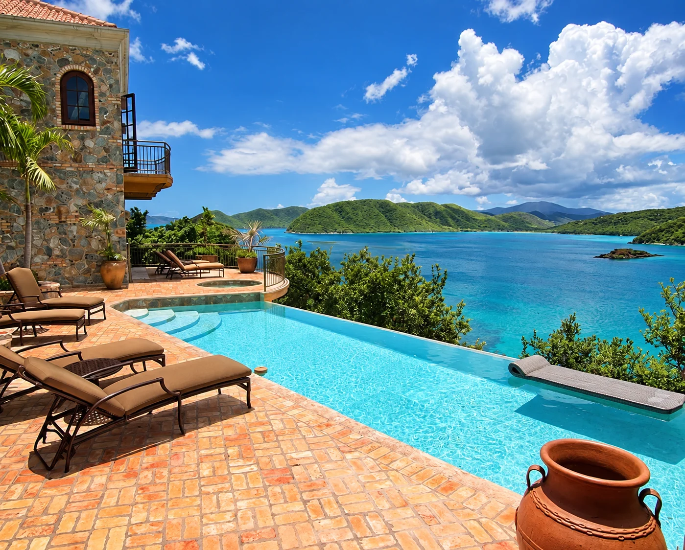 A stone villa and terracotta terrace with an infinity pool overlooking the bay in St. John