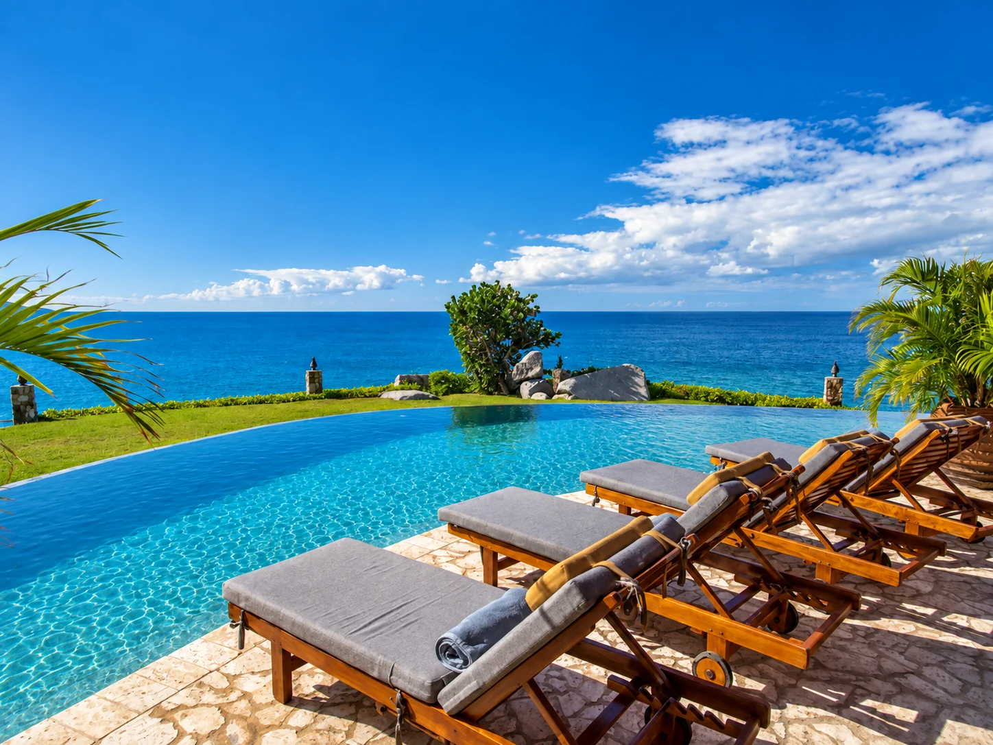 An infinity pool and wooden loungers overlooking the ocean in Virgin Gorda