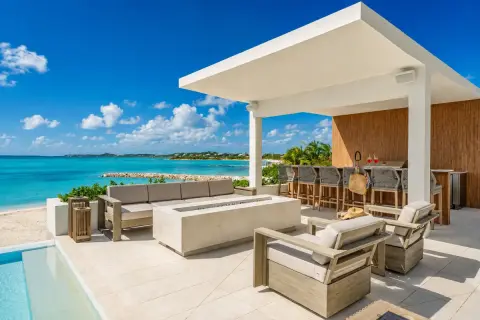 A contemporary private villa terrace overlooking turquoise water